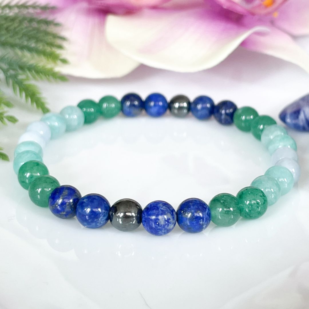 Multicolored beaded bracelet on a white surface with a floral background