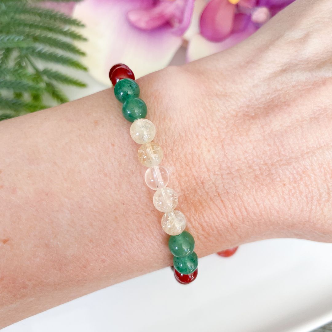 Beaded bracelet on a wrist with a blurred floral background
