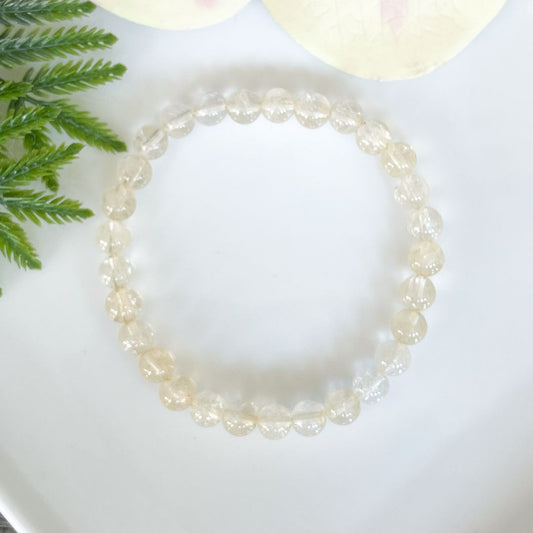 pale citrine bracelet on a white plate with green leaves