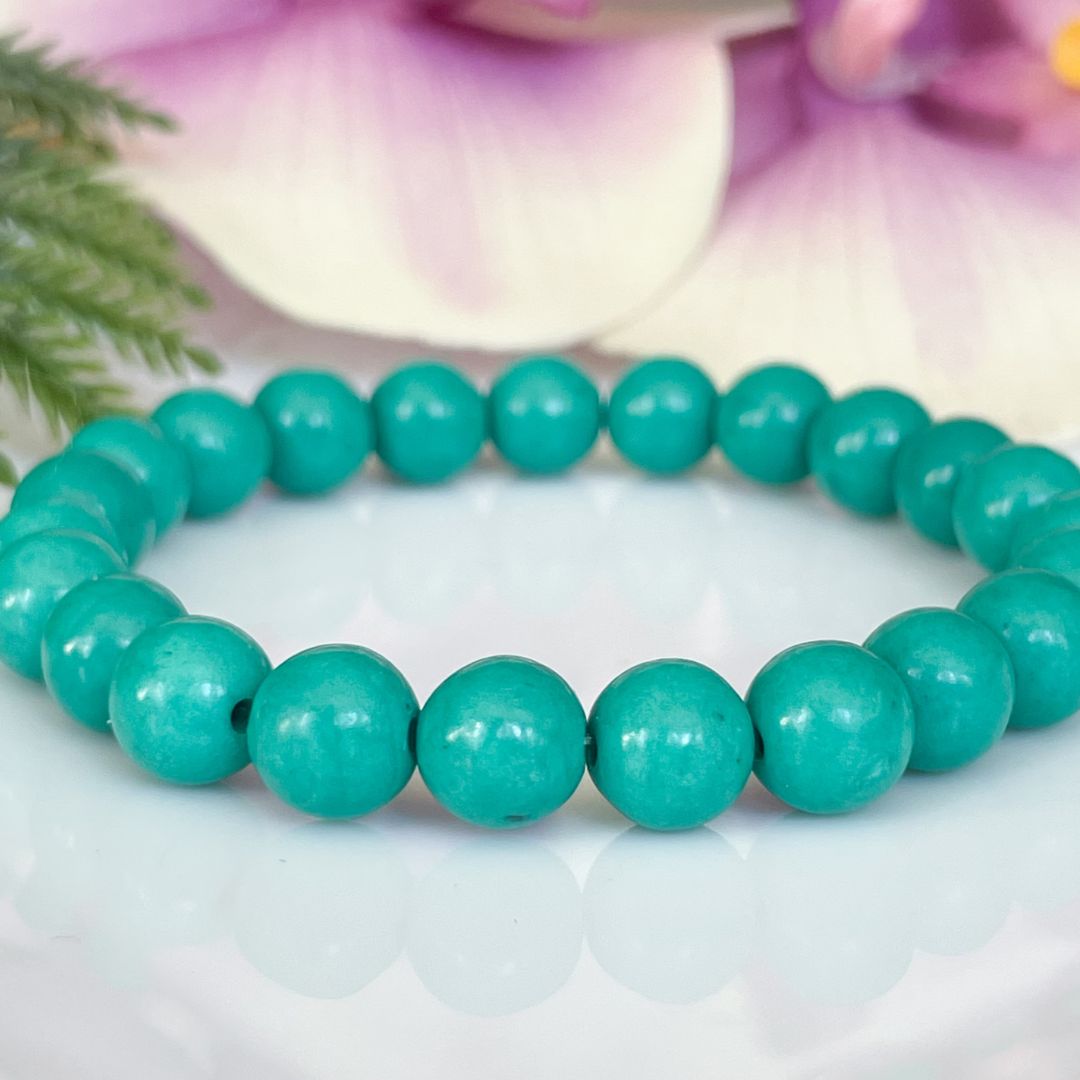 Turquoise beaded bracelet on a light background with floral elements