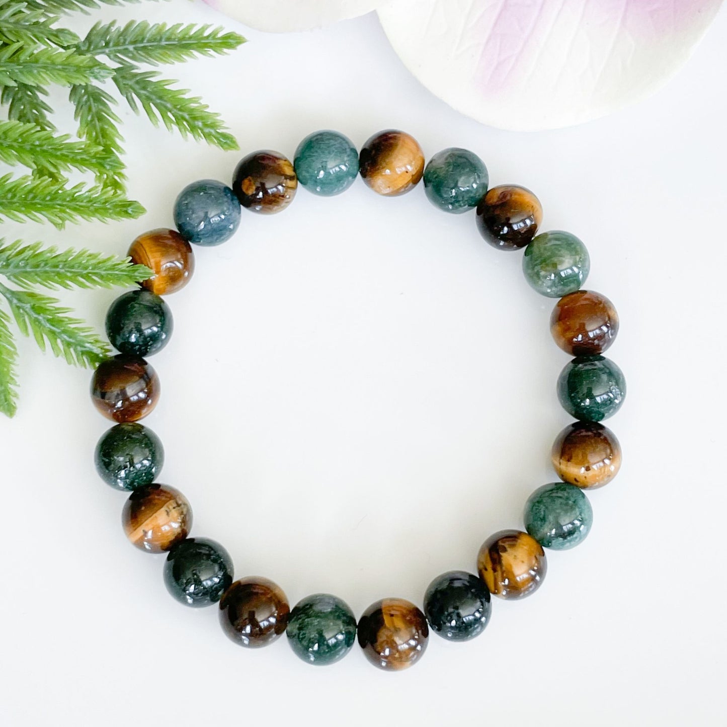 Overhead view of green moss agate and tigers eye bracelet